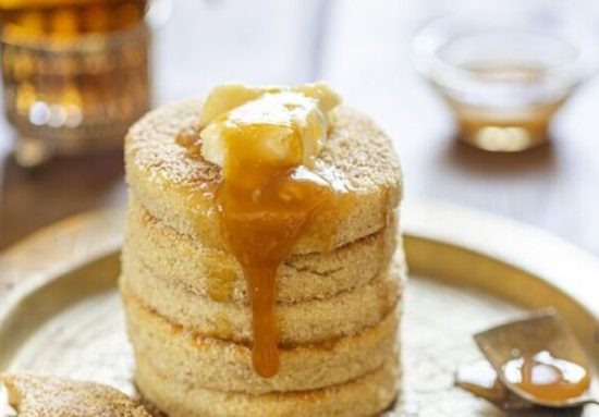 Moroccan Harcha Semolina pan fried. Flatbread served with honey or syrup made from melted butter and honey. Harsha is a traditional breakfast from the north of Africa, front view, close up.